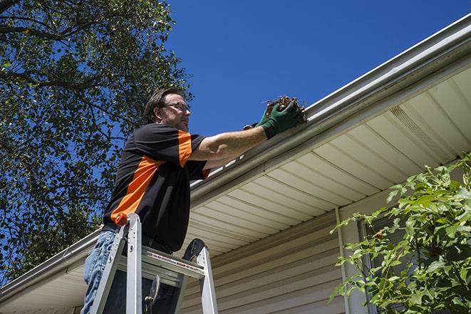 a worker conducting maintenance on a gutter in Barry